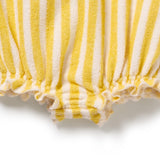 Close-up of yellow and white striped fabric with ruffled edge on a white background