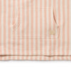 Close-up of a pink and white striped fabric with a brand logo on a white background