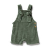 Green baby romper with bow straps on a white background