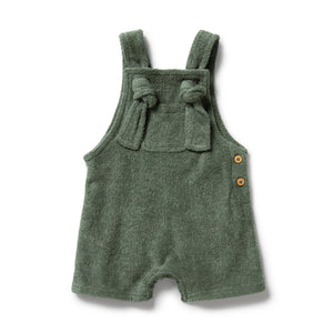 Green baby romper with bow straps on a white background