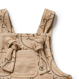 Beige children's overalls with black geometric patterns on a white background