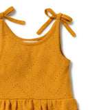 Close-up of a mustard yellow knit sleeveless top or dress with tie shoulder straps and a ruffled hem, shown on a white background.