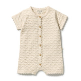A cream-colored short-sleeve baby romper with a textured wavy knit pattern, scalloped edges, and a front button closure, shown on a plain white background.