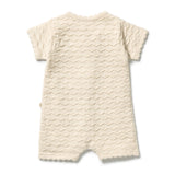 An off-white textured short-sleeve baby romper with scalloped edges, shown from the back on a white background.