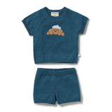 A toddler knit two-piece outfit set consisting of a short-sleeve top and matching shorts in a heathered teal blue color. The top features a cute embroidered brown bear wearing a white hat on the chest.