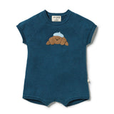A toddler's short-sleeve knit romper in teal blue, featuring an embroidered brown teddy bear wearing a light blue beret on the chest. The brand 'alva family' is visible on the inner neck label.