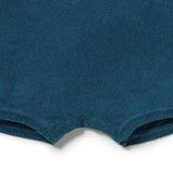 Close-up of a dark teal knit garment, showing the ribbed leg opening with three snap buttons on a white background.