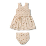 A two-piece baby outfit set consisting of a sleeveless smocked dress and matching diaper cover, both in a cream-colored ribbed fabric with a small brown polka dot pattern, shown on a plain white background.