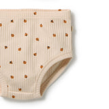 Close-up of a ribbed cream-colored baby diaper cover featuring a small brown ladybug pattern, shown on a clean white background.