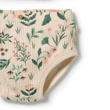 Close-up of a pair of ribbed baby bloomers in a warm cream color, featuring a green and pink botanical leaf pattern and a small wooden button closure at the waistband.