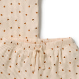 Close-up of a ribbed knit pajama set in a warm cream color with a small brown and orange floral pattern, featuring a drawstring waistband.