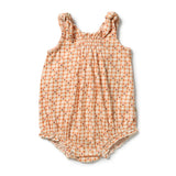 A baby romper in a light peach and orange gingham pattern with small embroidered floral details, featuring a smocked bodice and ruffled straps and leg openings.