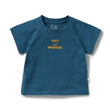 A toddler's short-sleeve crewneck t-shirt in a deep teal blue color, featuring the French phrase 'TOUT est MAGIQUE' printed in yellow on the chest. The shirt is displayed flat against a clean white background.