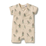A short-sleeve baby romper in a warm cream color, featuring an all-over print of cartoon bears wearing green shorts and running. The romper has a front zipper and is photographed flat against a clean white background.
