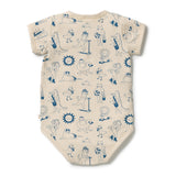 A short-sleeve baby bodysuit in cream with a blue cartoon dog pattern, laid flat on a white background.