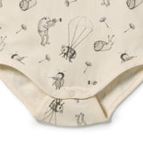 Close-up of a baby bodysuit in cream with a black and gray whimsical print of bees, snails, dandelions, and a parachute, featuring snap closures at the crotch.