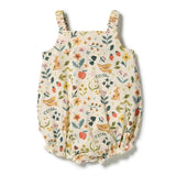 A baby bubble romper with a delicate floral and nature print on a cream background, featuring illustrated bunnies, birds, strawberries, and wildflowers. The garment has ruffled shoulder straps and a ruffled hem, shown flat on a white background.