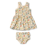 A baby girl's two-piece outfit set consisting of a sleeveless smocked dress and matching bloomers, both featuring a delicate multicolor floral and bird pattern on a warm cream background.