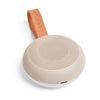 Beige portable speaker with brown leather strap on a white background