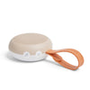 Portable speaker with a beige top and white bottom, featuring an orange handle on a white background.