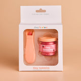 Product packaging of 'tiny tummies' with a pink jar and orange spoon on a beige background.