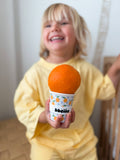 Child holding a toy resembling an orange in a cup with 'bbeme' branding.