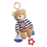 Teddy bear toy with striped shirt and colorful accents on a white background