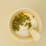 Cup of coffee with passion fruit syrup and cream on a beige background