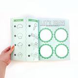 Hand holding a coloring book with drawing prompts on a white background