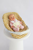 Baby doll in a yellow checkered seat with a white background