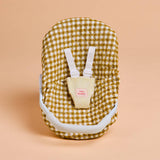 Baby nest with checkered pattern and white straps on a beige background