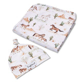 A baby gift set featuring a folded muslin swaddle blanket and a matching beanie hat, both printed with a western desert theme including horses, cacti, and mountains on a white background. The brand name 'Simply Honey' is visible on the hat's label.