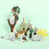 Set of wooden animal figurines on a light green background