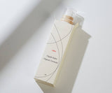 Nipple balm packaging with a dropper on a light background