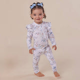 Child wearing a floral outfit on a beige background