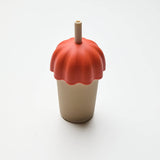 Ceramic tumbler with a red lid and straw on a white background
