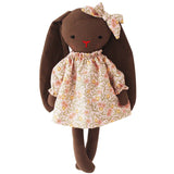 Stuffed bunny toy wearing a floral dress on a white background