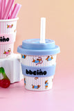 Stackable cups with blue lids and 'bbeeinó' branding on a pink background