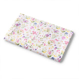 A folded white muslin swaddle blanket with a colorful watercolor-style wildflower print, shown on a clean white background.