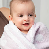 Baby wrapped in a pink towel with a neutral background
