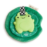 Green plush toy with a turtle design on a green base, featuring a checkered strap and a brand tag.