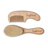 Close-up of Snuggle Hunny natural wooden baby hairbrush showing soft nylon bristles and engraved handle.