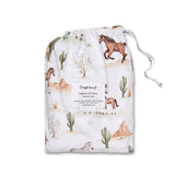 A drawstring storage bag for a baby care product, featuring a western desert print with cacti, mountains, and horses on a white background. The brand name 'Simply Heavenly' is visible on the central label and the drawstring.