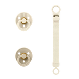 Two beige pacifiers with a strap on a white background