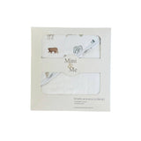 A boxed baby towel and washcloth set on a plain white background. The cream-colored packaging features two clear window cutouts showing the white cotton towels with a safari animal print, including a brown bear, gray elephant, and small birds.