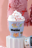 Cartoon-themed cup with whipped cream on a pink background