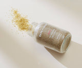 BareMinerals skin brightening powder spilling out of a bottle on a light background