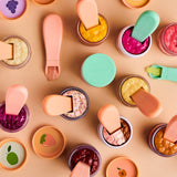Colorful makeup products with applicators on a beige background