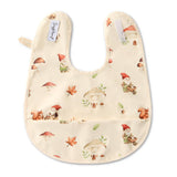 Baby bib with forest-themed design featuring gnomes, mushrooms, and squirrels on a white background.