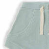Close-up of a light blue corduroy shorts with a pocket and white trim on a white background